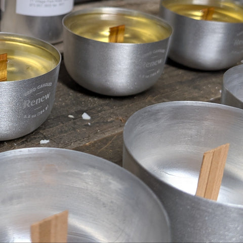 Recyclable aluminum candle containers being filled